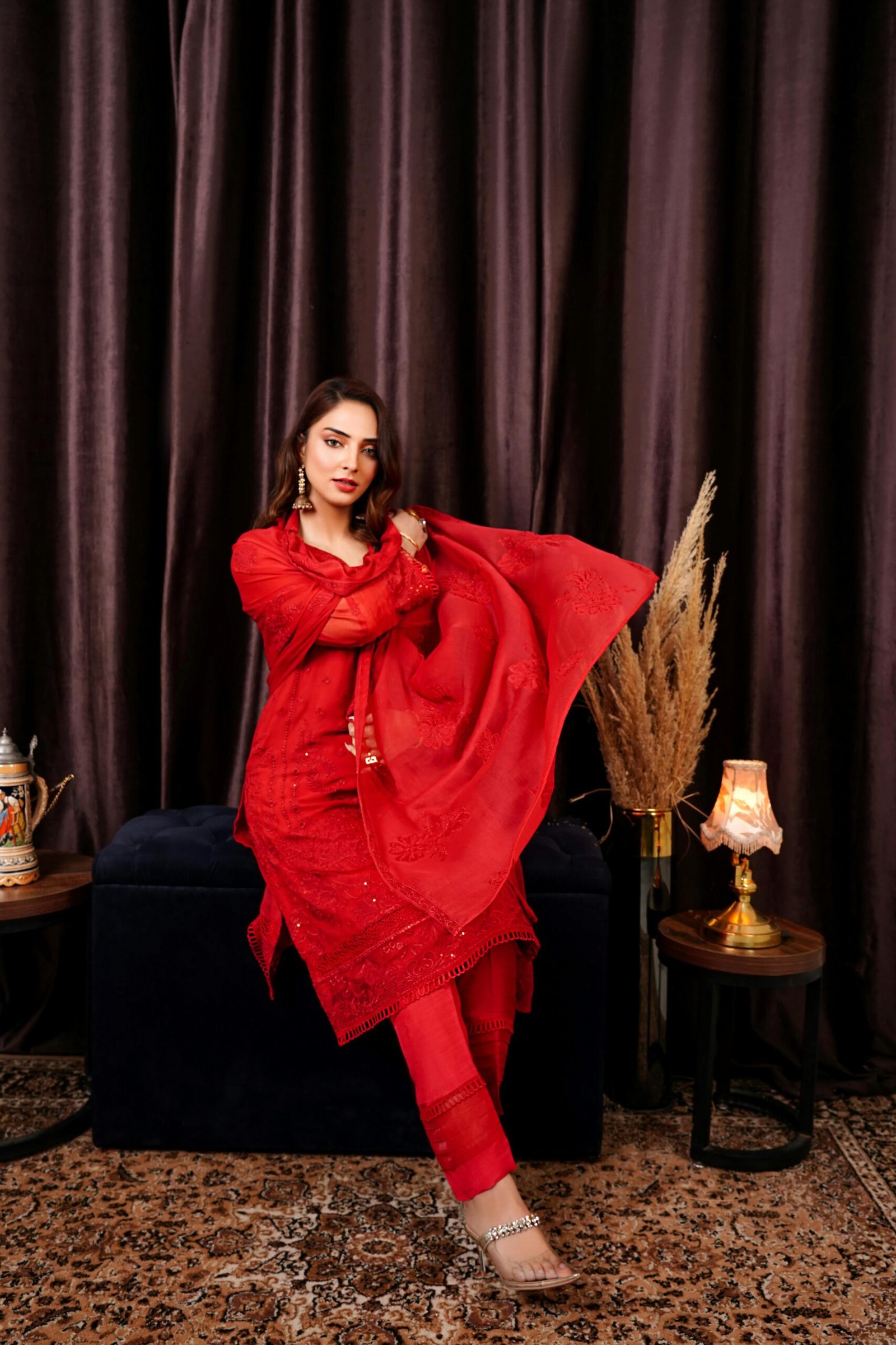 Home Portrait of a woman in traditional red attire in an elegant indoor setting. Perfect for cultural and fashion themes.