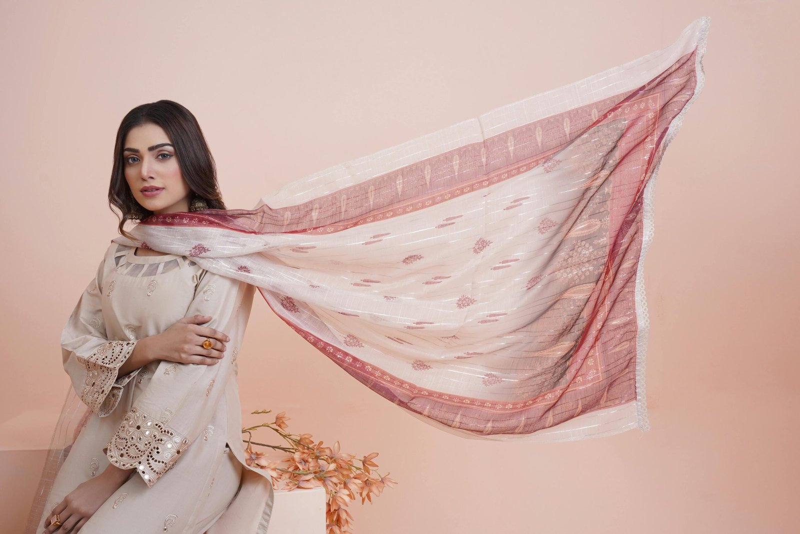 Home Woman in traditional attire with a scarf flowing elegantly indoors.